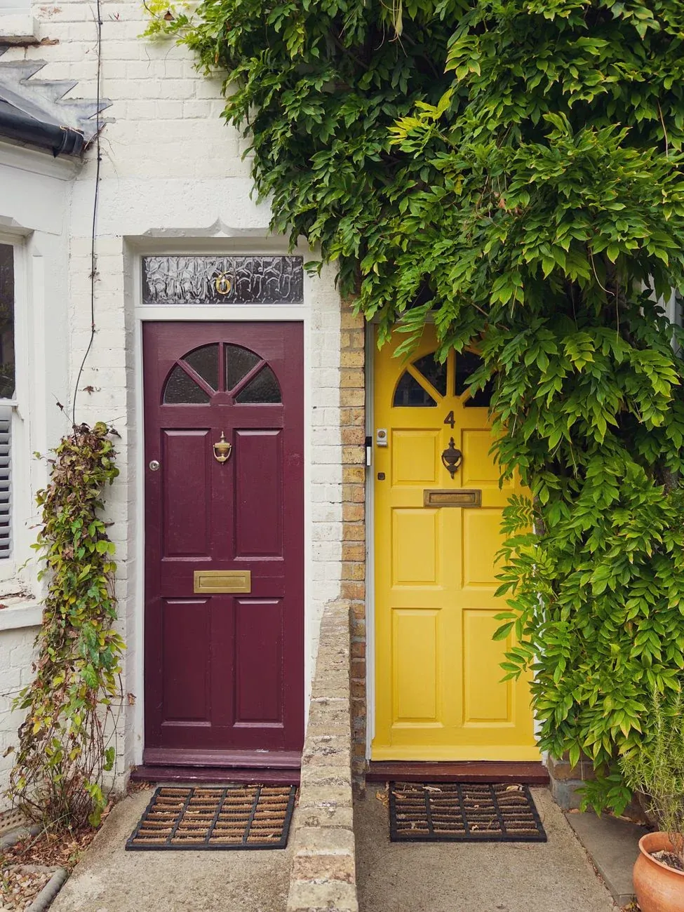 A purple and a yellow front door side by side on a terrace